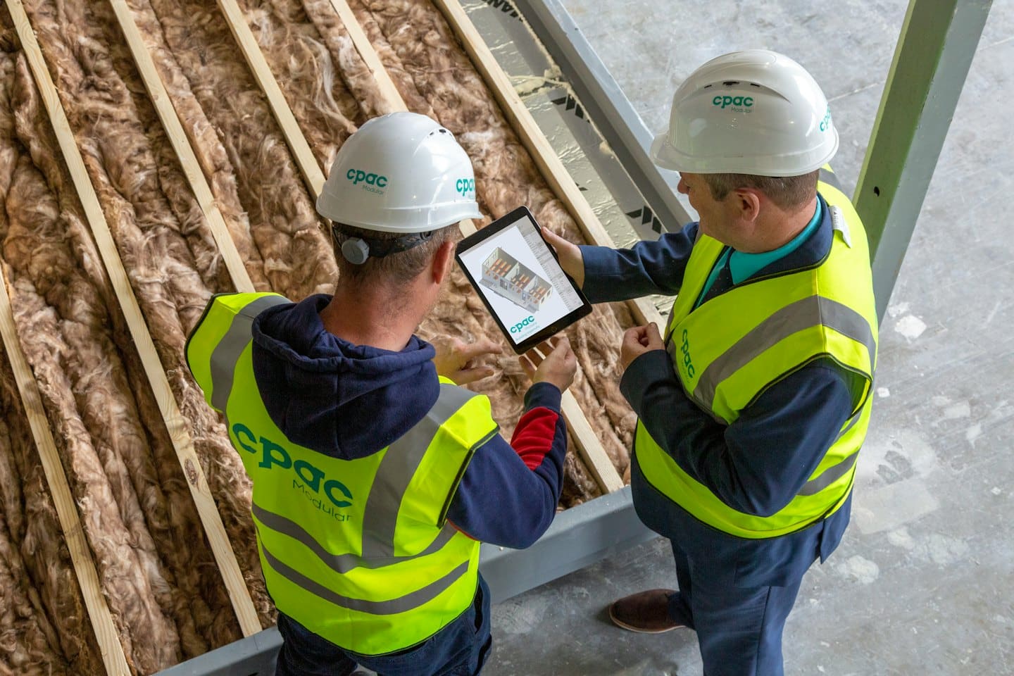 Byggarbeidere ser på byggeplaner på et nettbrett.