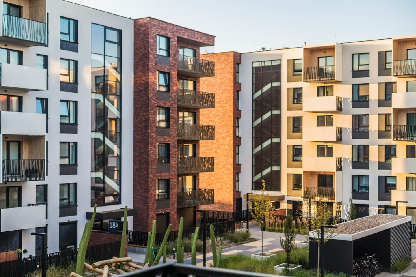 Moderne leilighetsbygg med balkonger og glassvinduer.
